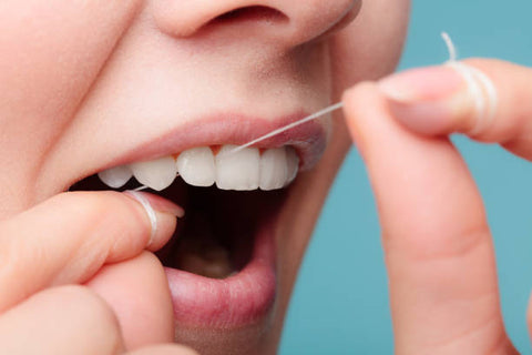 a woman using dental floss made of nylon