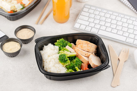 Netherlands: New rule for plastic to-go packaging from July - with someone eating in front of the computer with plastic containers
