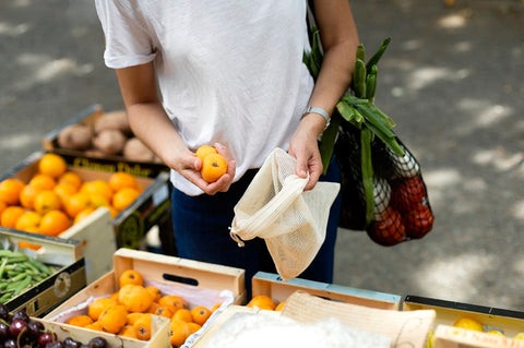 refuse single use plastic - woman is buying using a reusable mesh bag